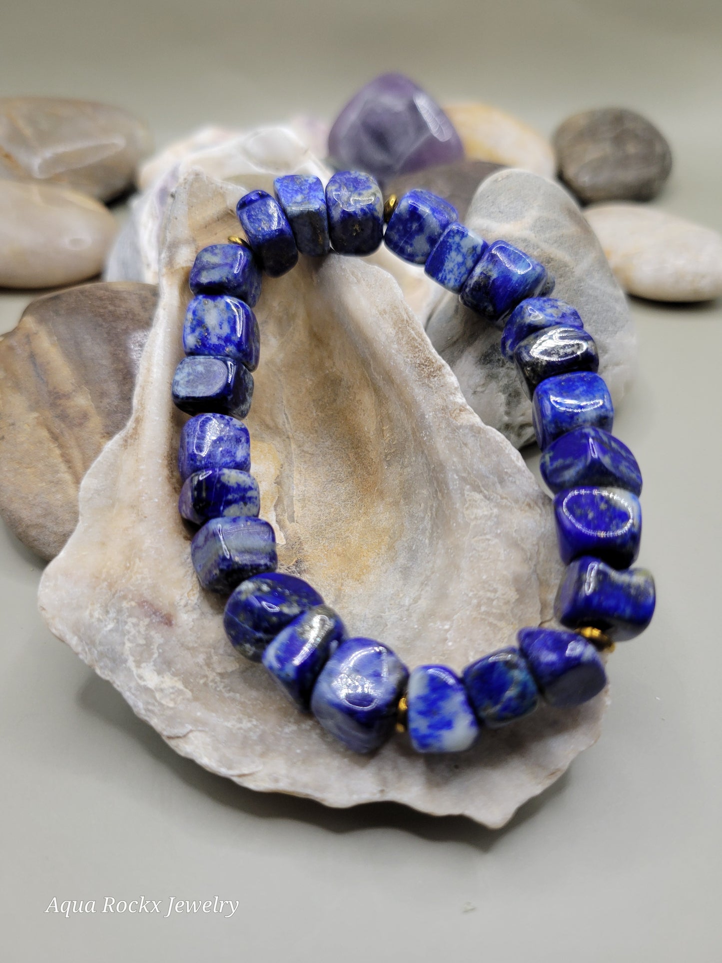 Blue beaded bracelet on a shell with a blurred background
