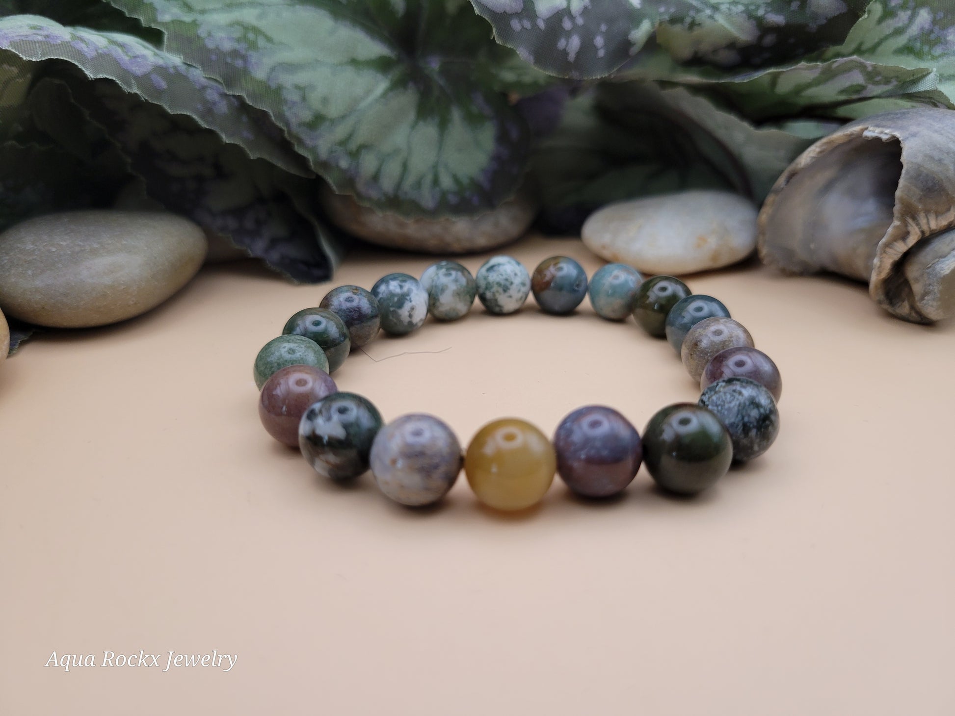 Multicolored Fancy Jasper beaded stretch bracelet on a beige surface. with 