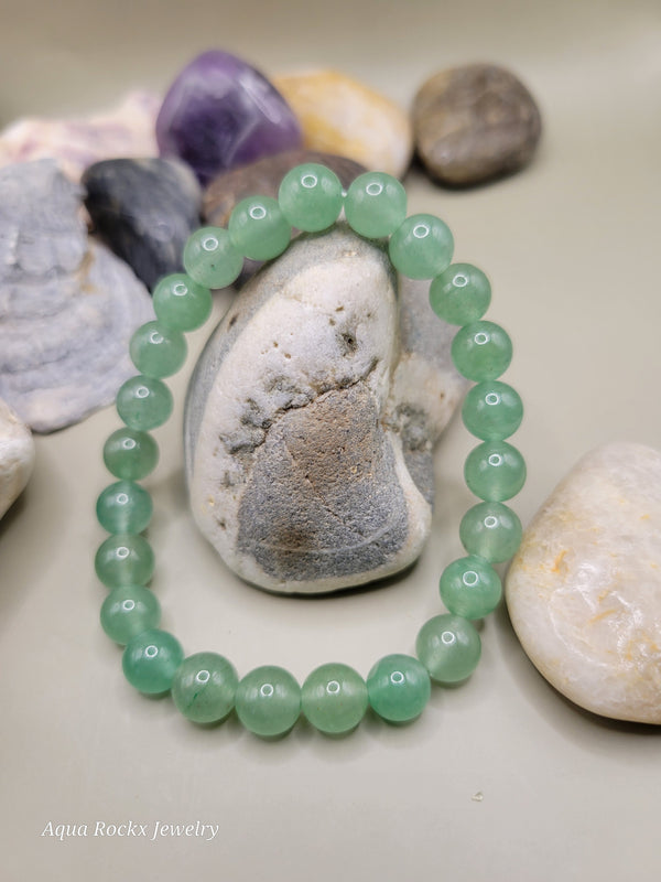 Green beaded bracelet on a pile of stones.