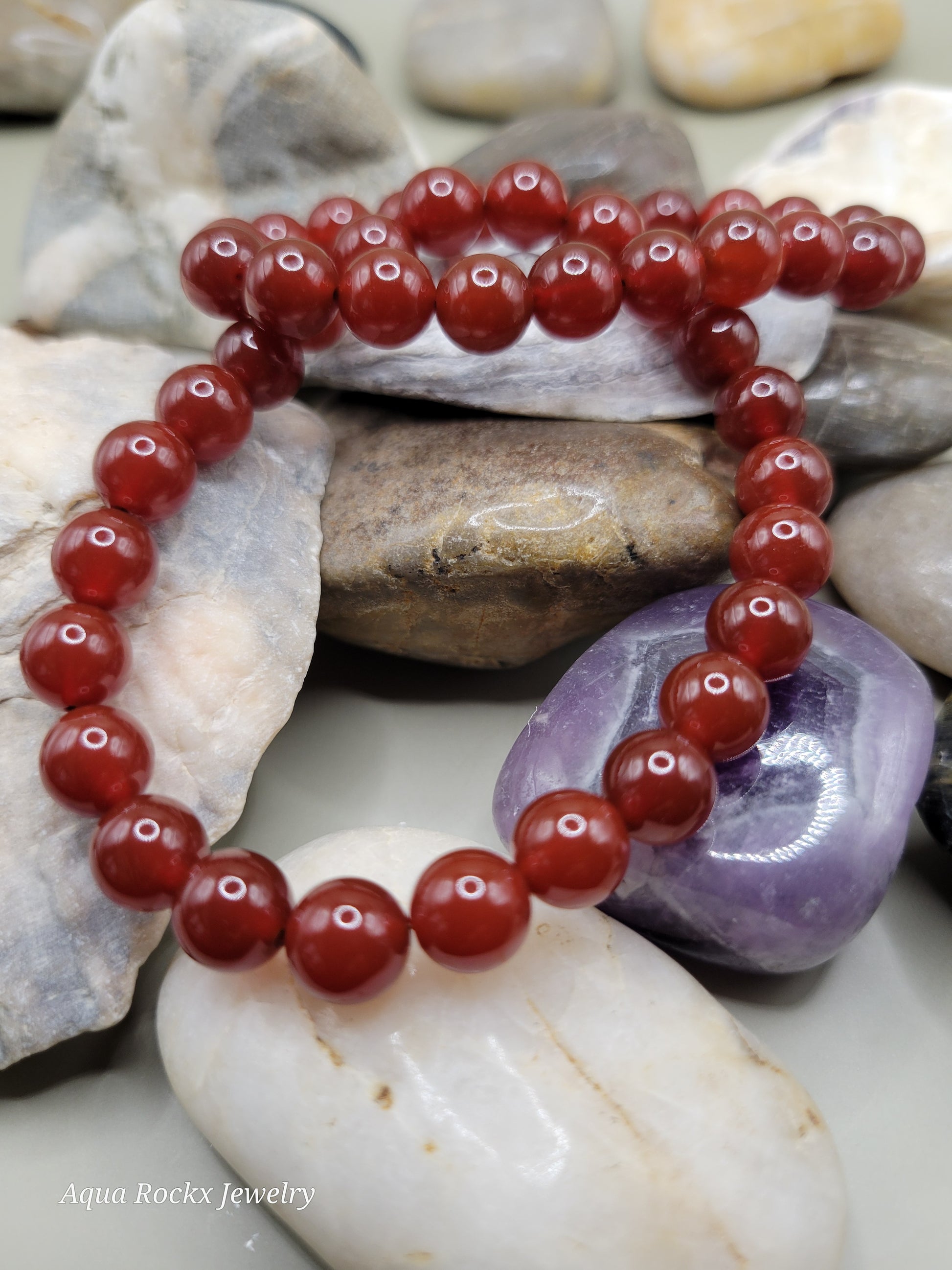 Orange beaded bracelet on a bed of stones 