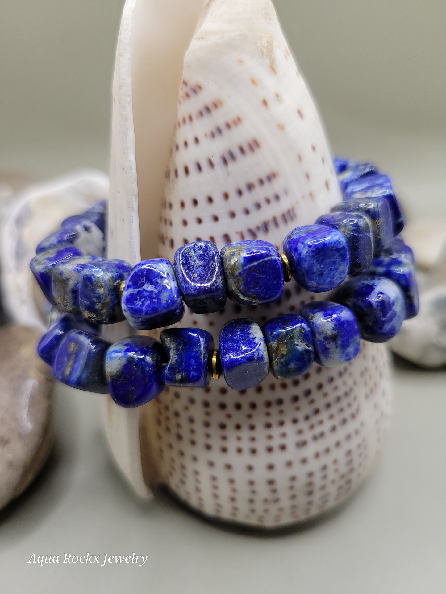 Blue beaded bracelet on a shell with blurred background