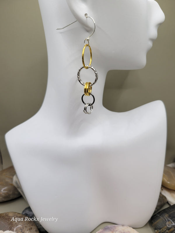 Three gold rings on a mannequin bust with a neutral background