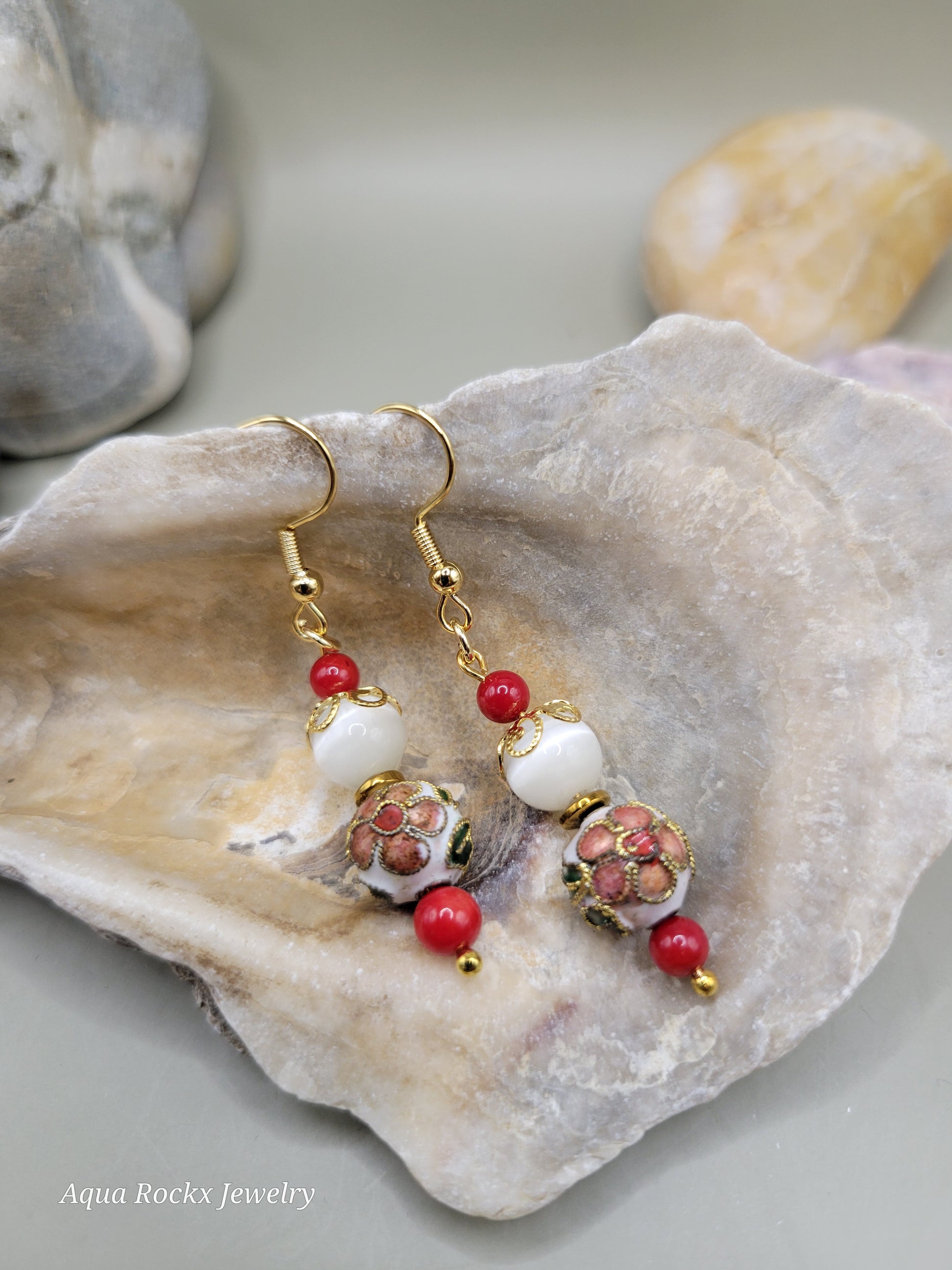 Jewelry with red beads and floral elements on a shell