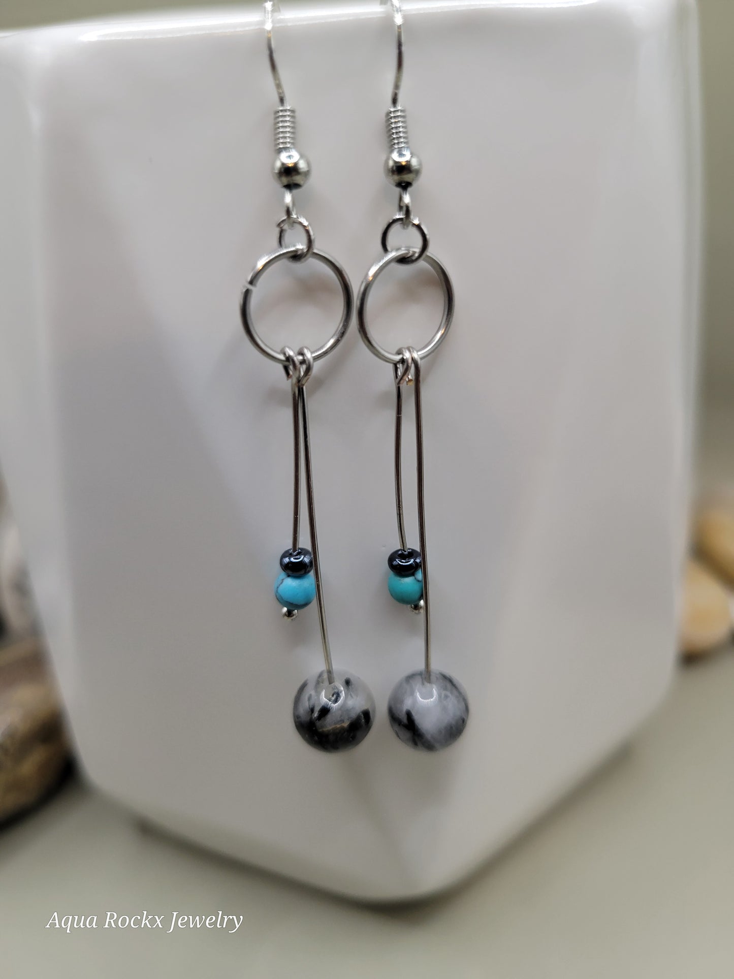 Pair of earrings with marbled beads on a white surface