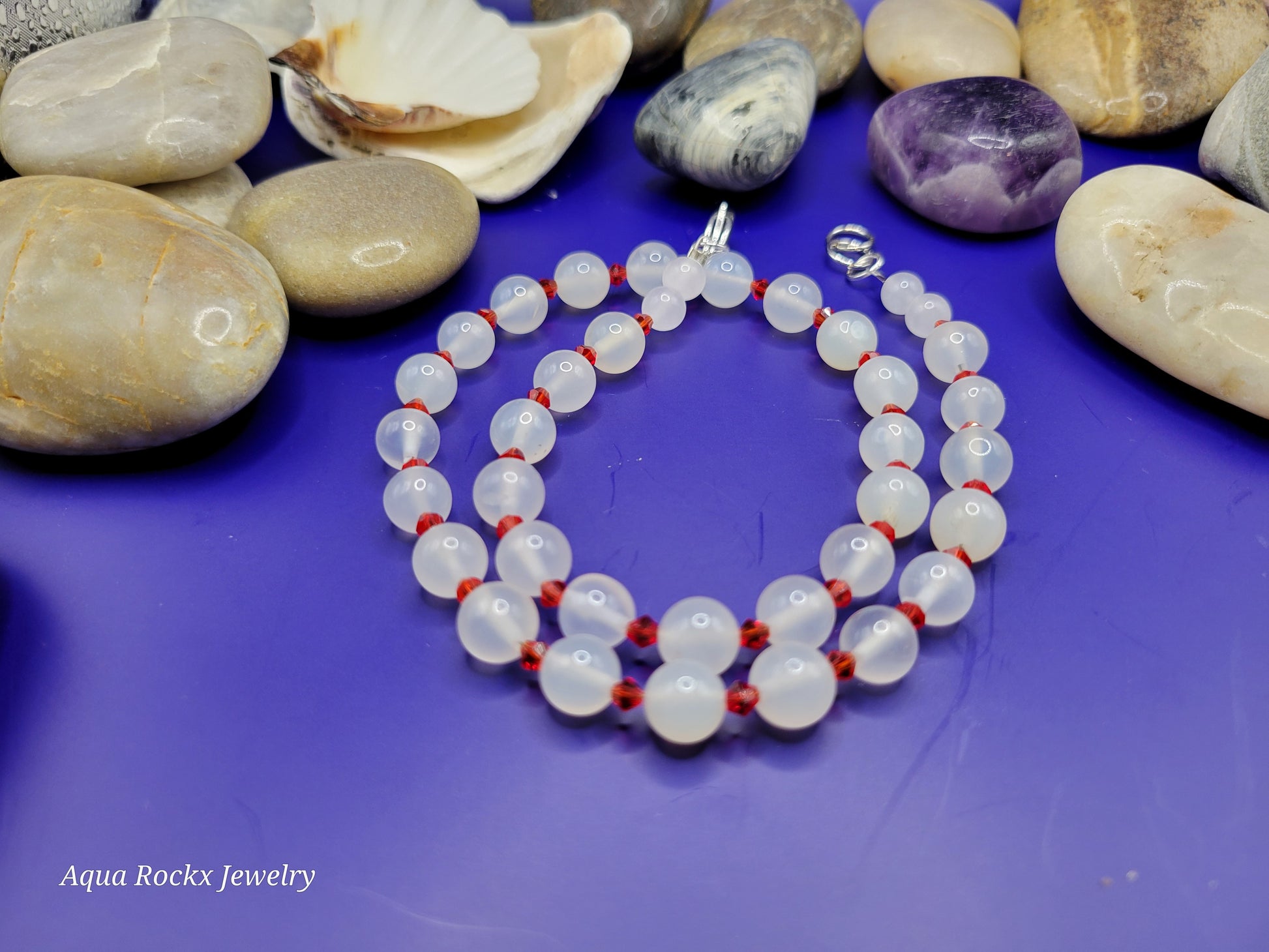 Necklace with white beads and red accents.