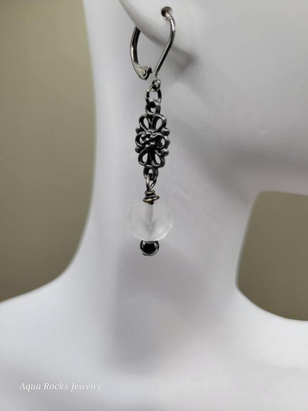 Silver earring with floral design on a white background