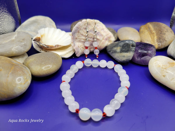 White quartz beaded bracelet and earrings with red accents.
