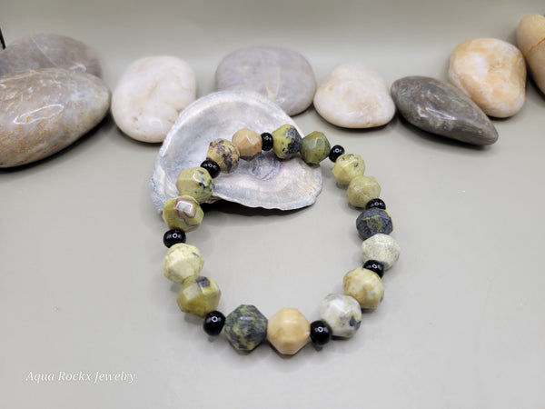 Bracelet with natural stone beads on a light gray background with stones.