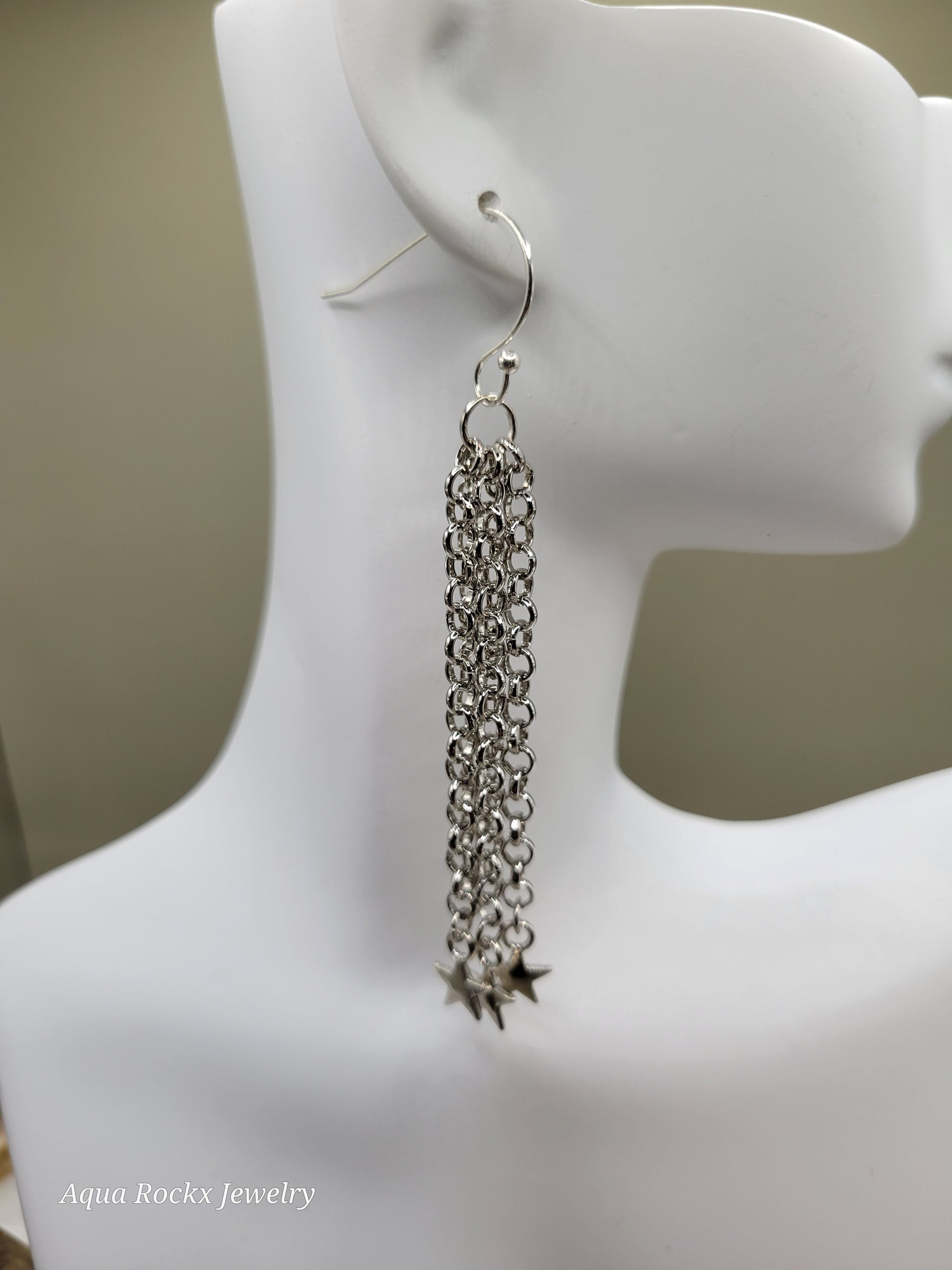 Silver chain earring on a mannequin ear with a neutral background